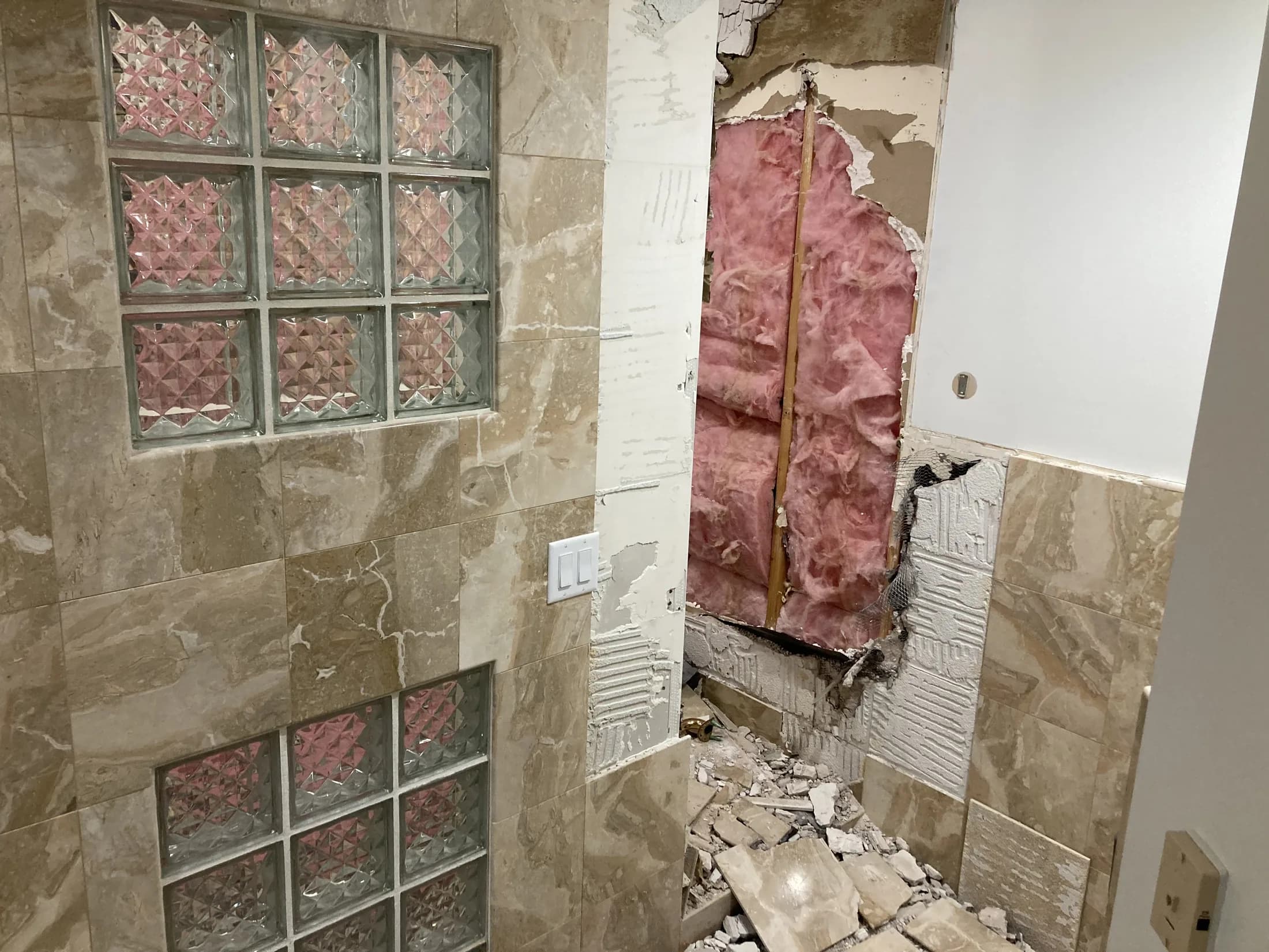 Bathroom tile and glass-block wall during demolition.
