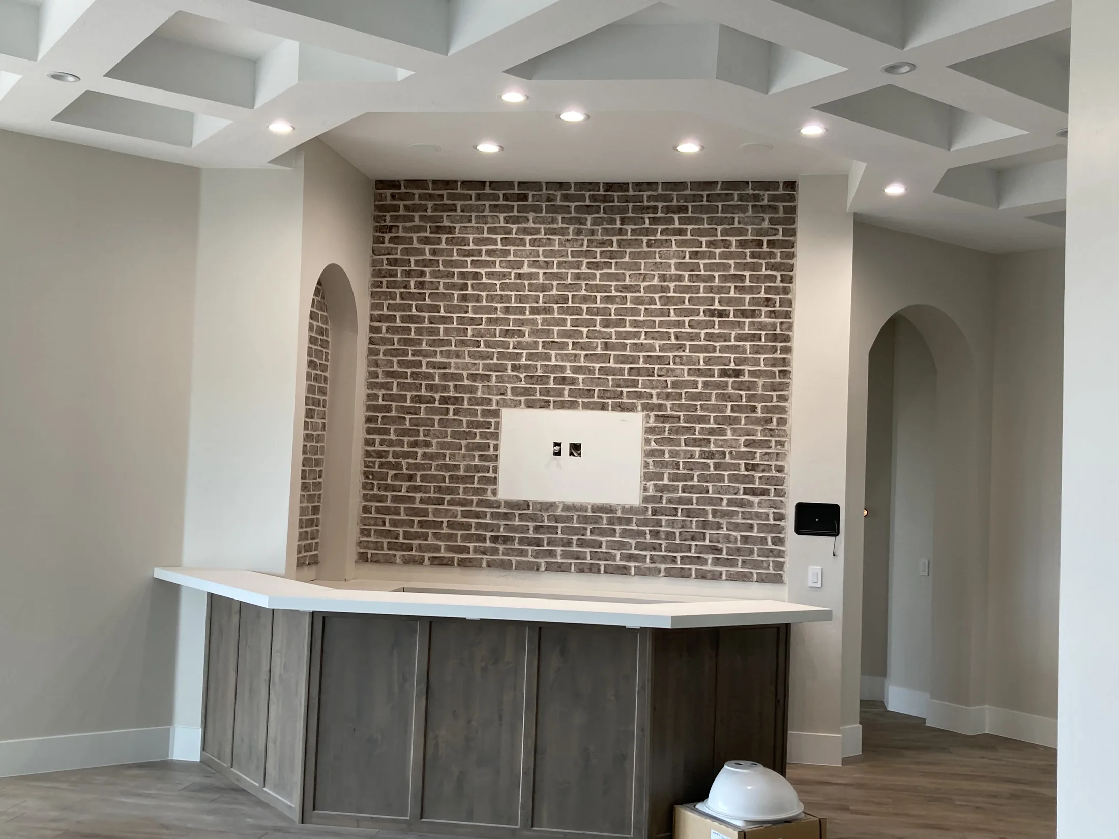 Brick media wall framed by custom cabinetry in a bright living space.