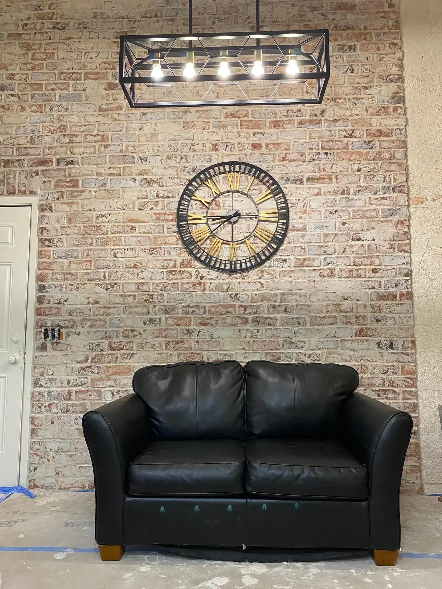 Stacked-stone living-room feature wall behind a leather sofa.