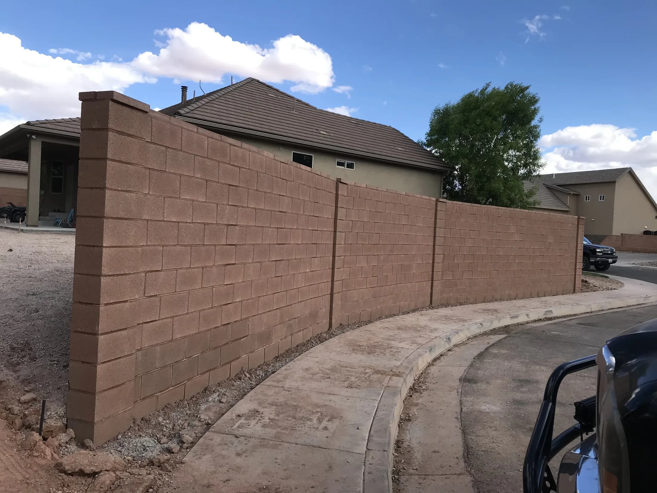 Concrete masonry boundary wall under construction.