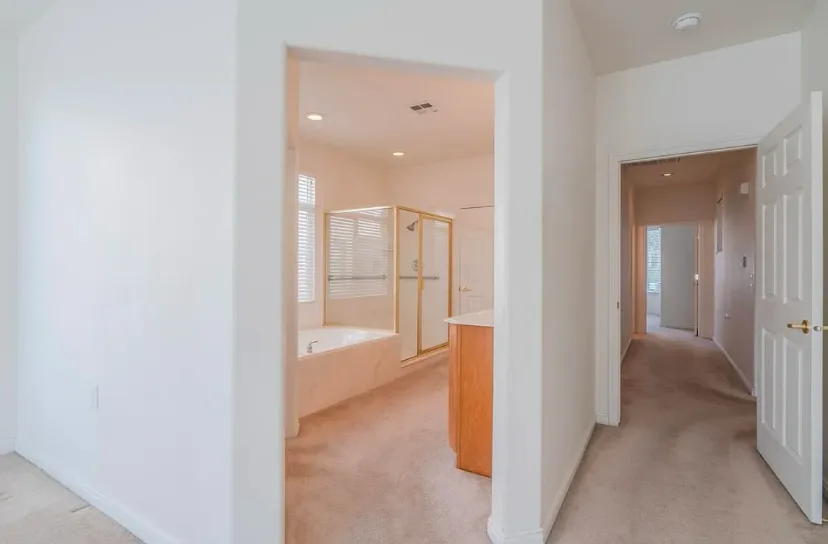 Bright remodeled hallway with white doors and light flooring.
