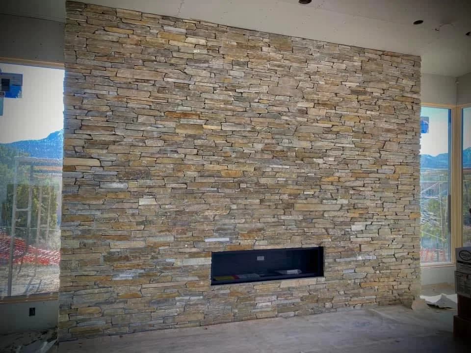 Wide ledgestone feature wall with a linear fireplace.
