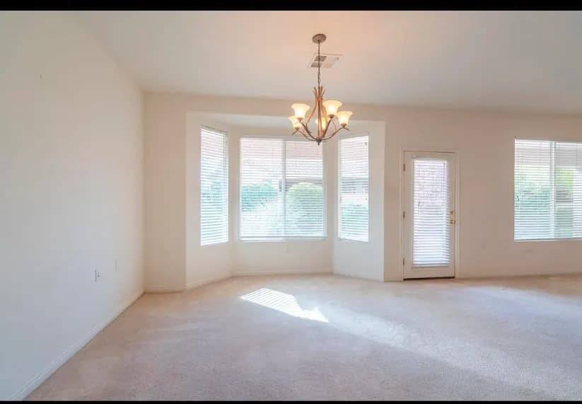 Finished open living room with broad windows and glass doors.
