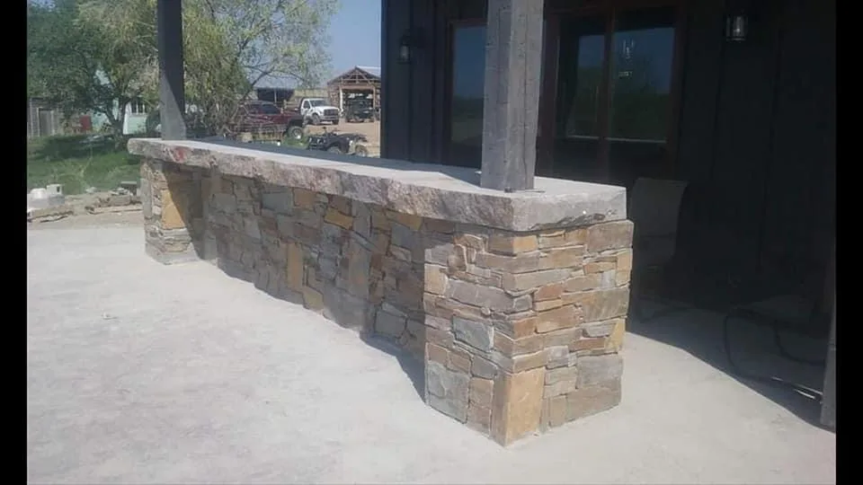 Stone-clad outdoor counter and gathering wall.