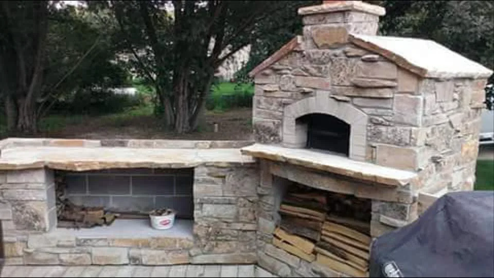 Rustic stone outdoor fireplace and cooking hearth.