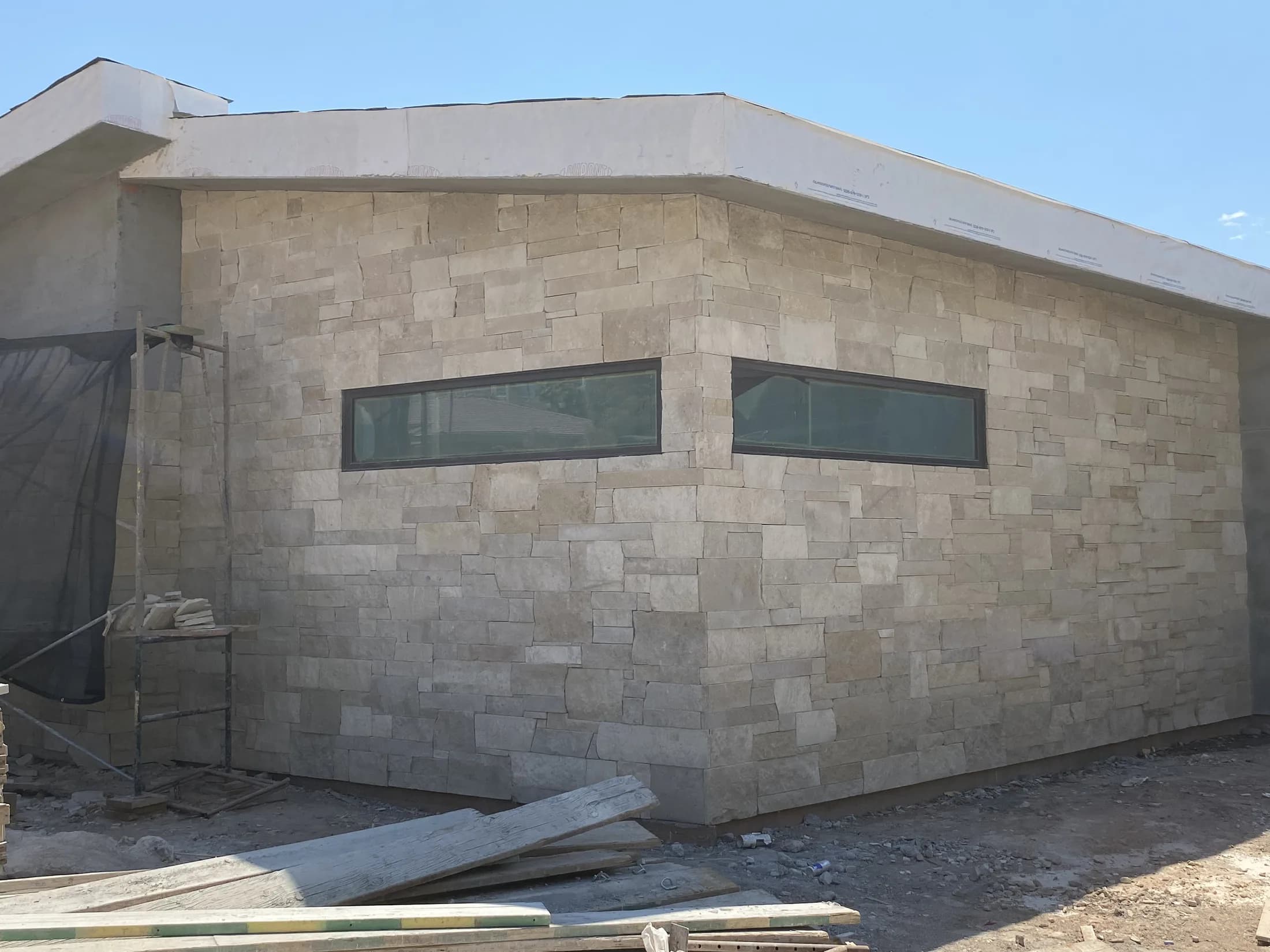 Stone-clad exterior wall with narrow modern windows.