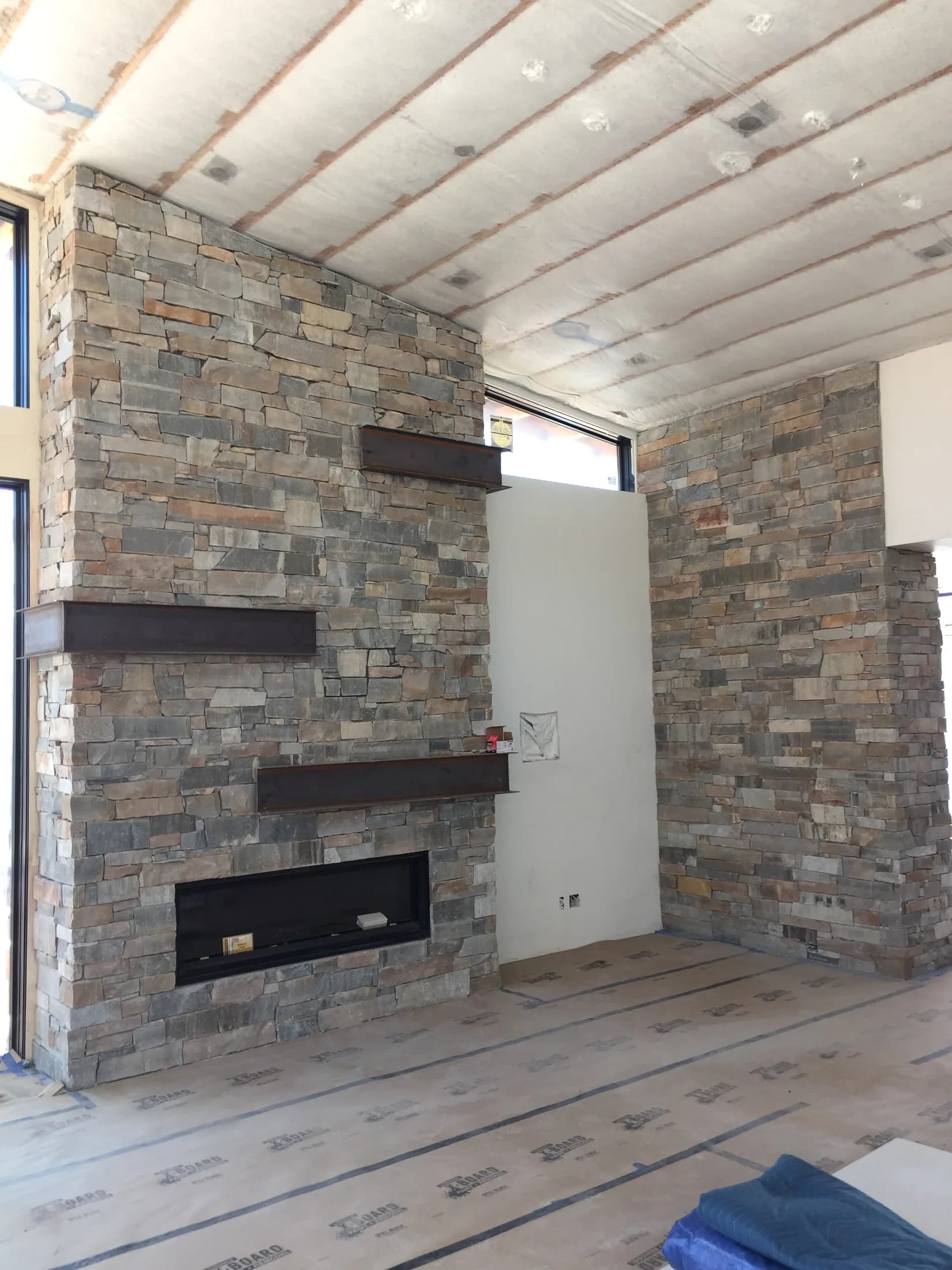 Stone fireplace built into a covered outdoor patio.