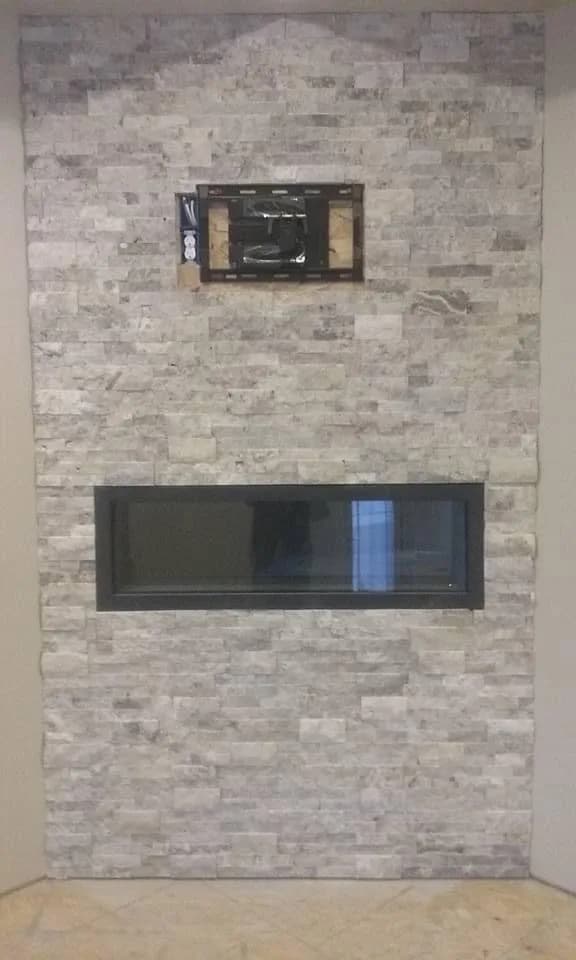 Floor-to-ceiling stacked-stone fireplace with a linear firebox and media niche.