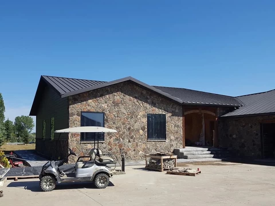 Stone-clad home exterior during construction.