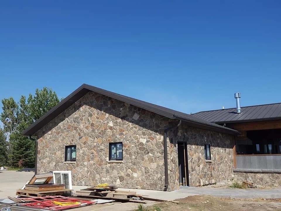 Natural-stone home exterior during final construction.