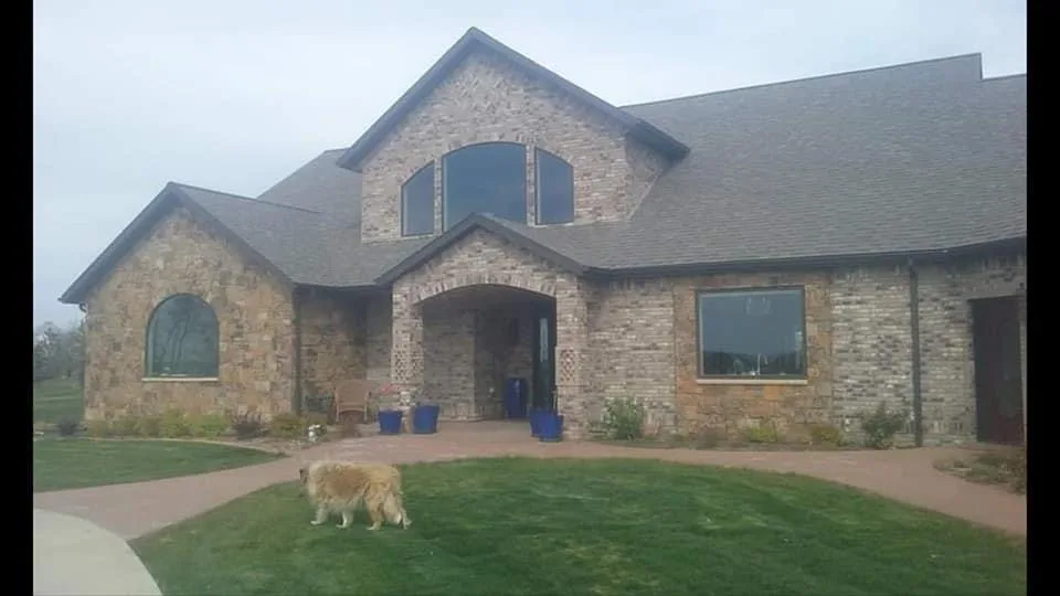 Stone-clad custom home with a deep arched front entry