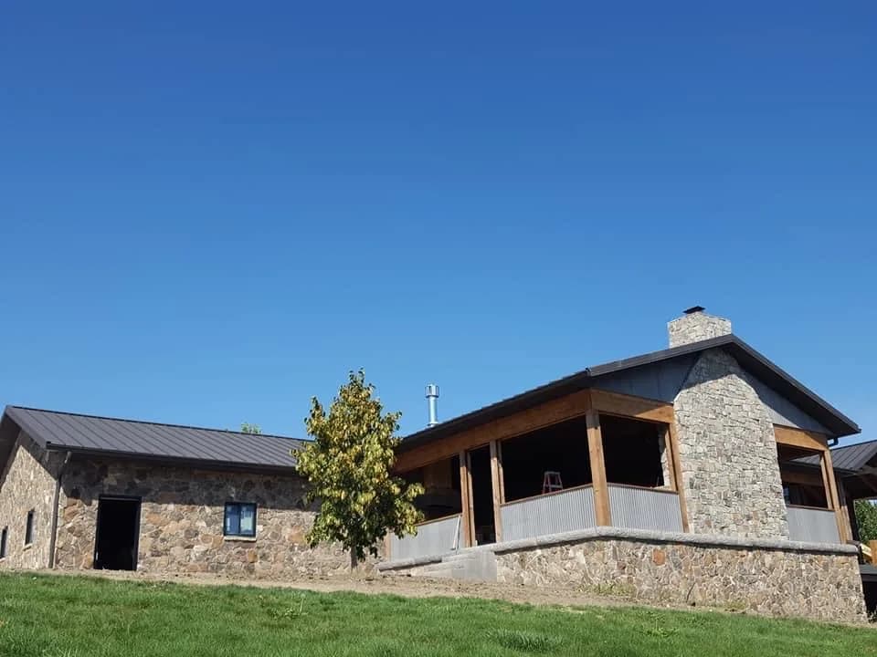Finished stone ranch exterior with a covered patio.